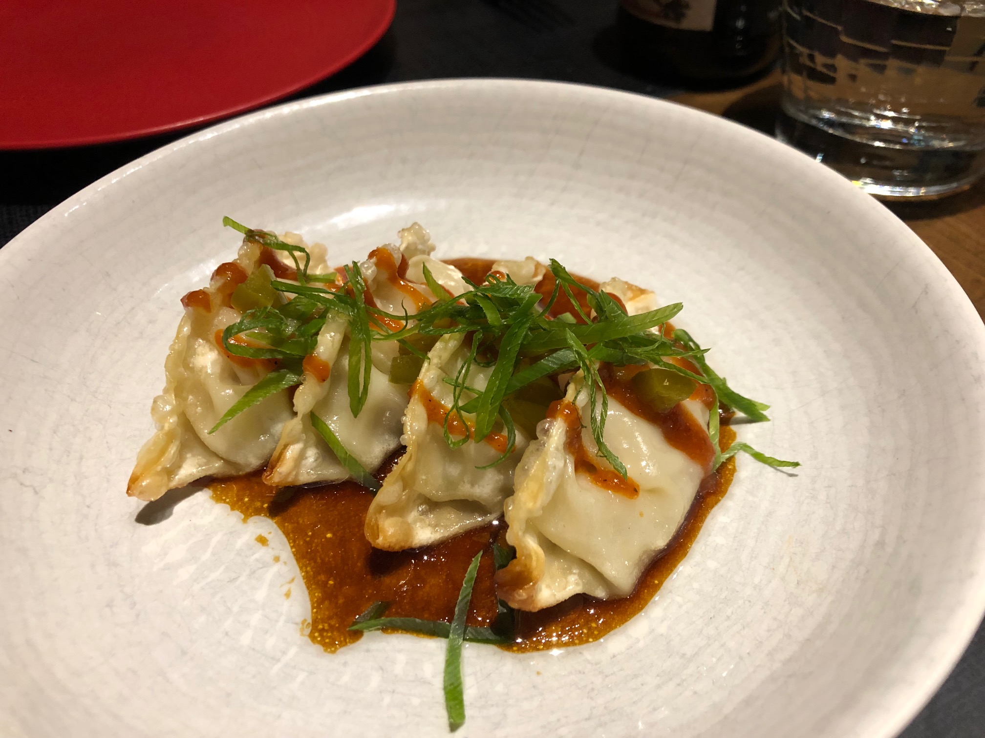 Dumpling de cerdo asado con hoisin de pimiento asado, cebolleta china y yuzu-ponzu